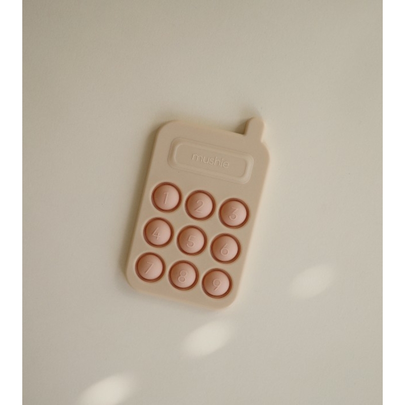Mushie pukkasztós játék telefon - halvány rózsaszín